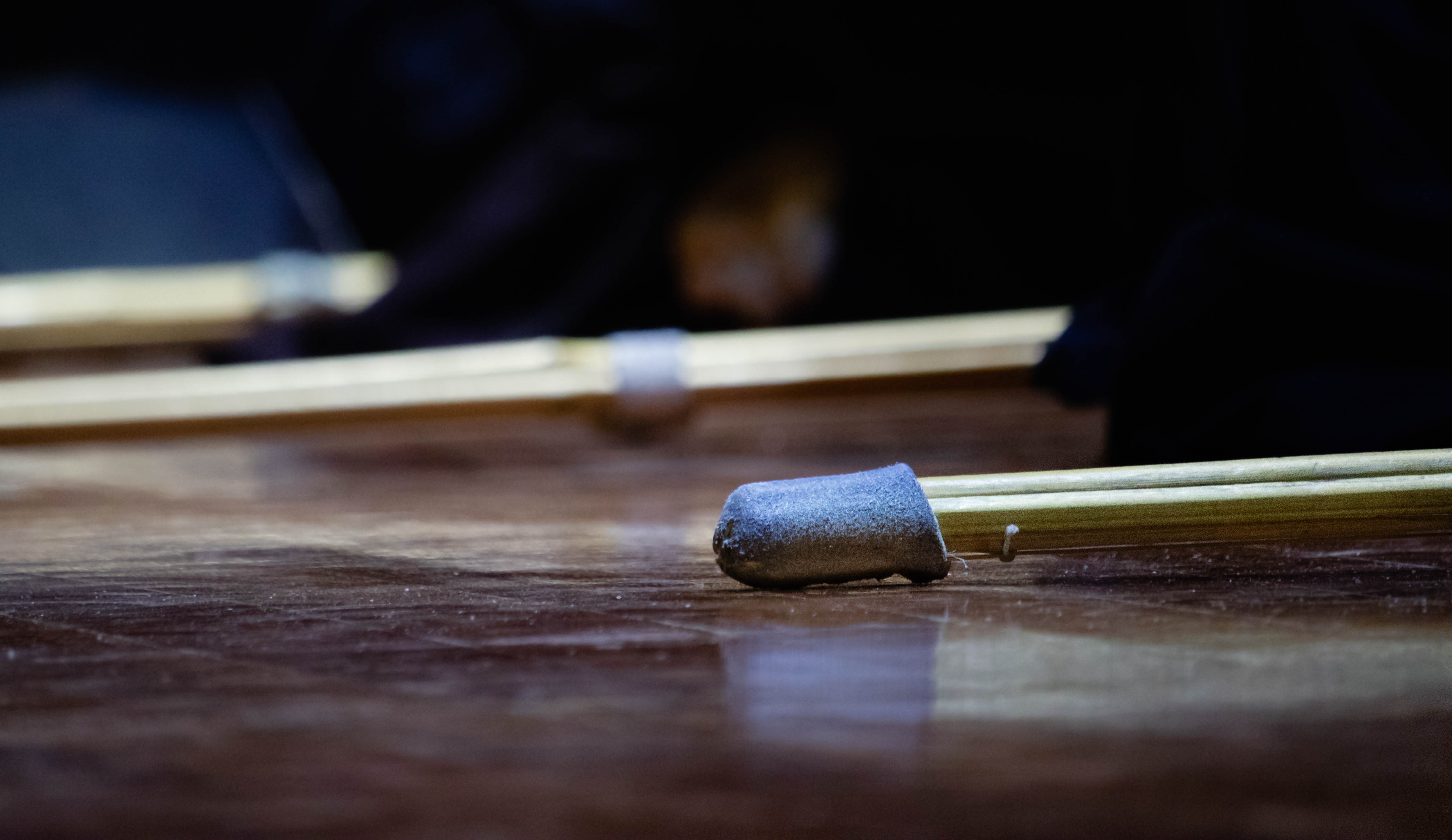 Detailed-view-of-three-shinai-on-the-dojo-floor